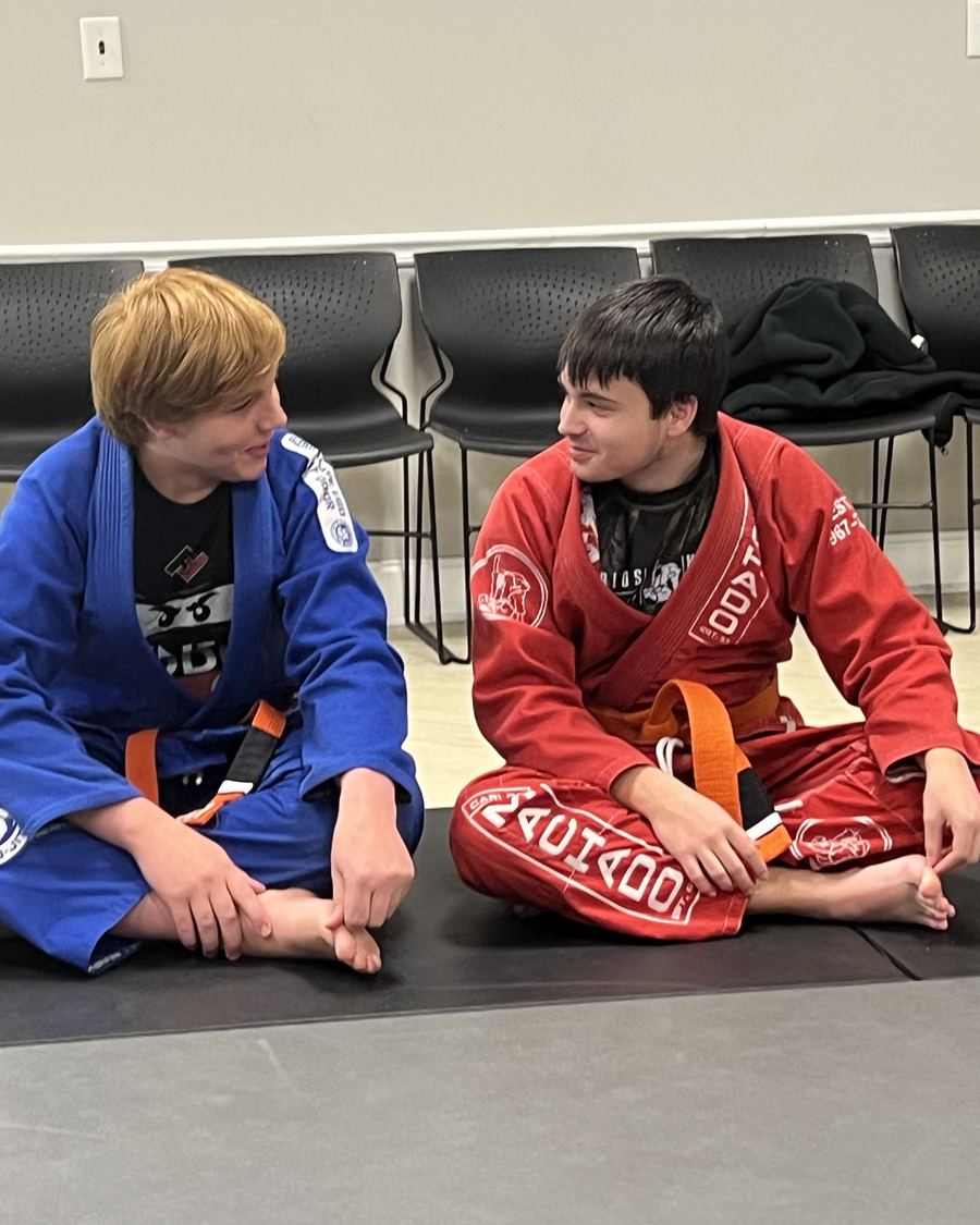 Two students in jiu-jitsu gis on the mat before class at Family First Martial Arts Spring Hill