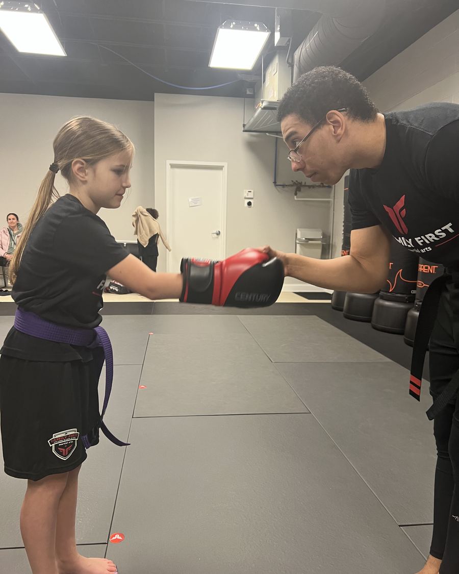 Coach Brendan holding pads for a young student at Family First Martial Arts Spring Hill