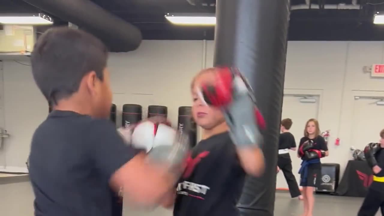 Coach holding pads for a young student during a Family First boxing drill in Spring Hill, TN